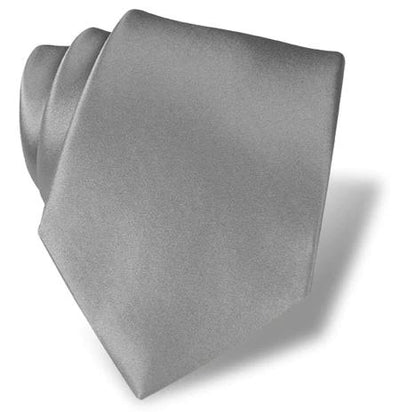 The DION Solid Silk Tie by Dion, in light gray, is neatly rolled and placed on a white surface, casting a shadow to the right—ideal for formal occasions.