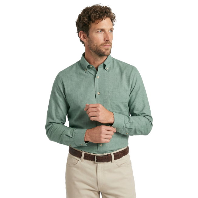 Man wearing a green button-up shirt and beige pants on a white background
