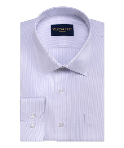 The Wilkes & Riley Twill Stripe Dress Shirt is a light blue, slim fit shirt with a subtle stripe pattern, front pocket, and buttoned cuffs. It is neatly folded and features the Wilkes & Riley brand label.