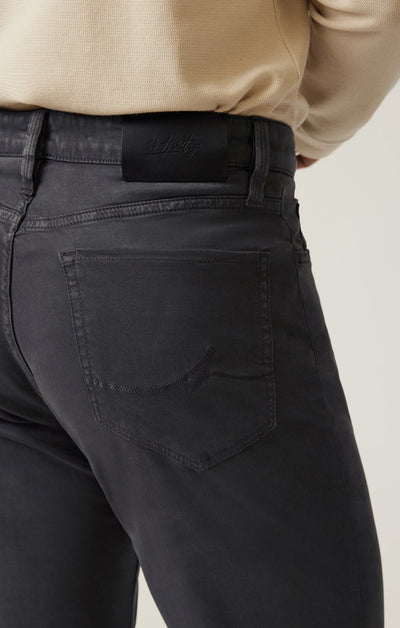 Close-up of the back of a person wearing 34 Heritage Ash Twill jeans and a beige top, showing a pocket detail and black waistband label from 34 Heritage.
