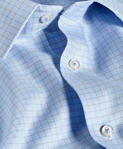 Close-up of the David Donahue Twill Check Dress Shirt TBSP12809489, featuring a light blue grid pattern, white buttons, and slightly wrinkled Pima cotton fabric for added texture.