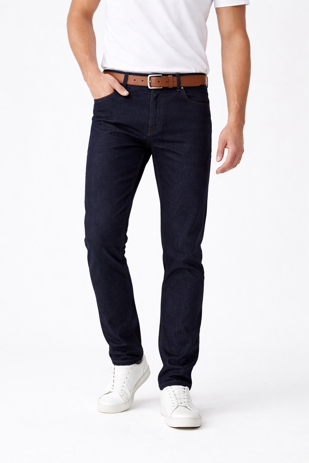 Person wearing navy blue jeans with a white shirt and white sneakers on a white background