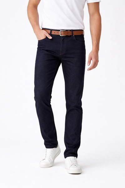 Person wearing navy blue jeans with a white shirt and white sneakers on a white background