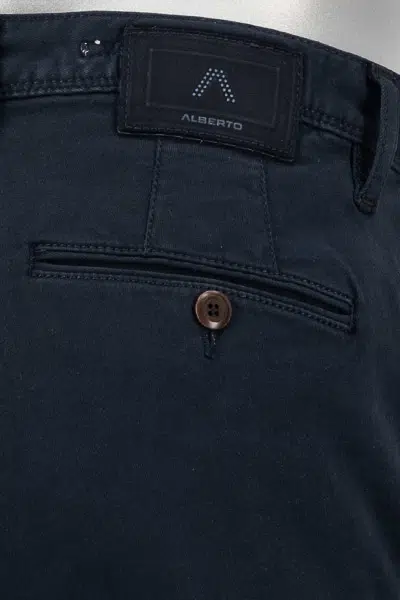 Navy blue pants with a brand label on a metallic surface