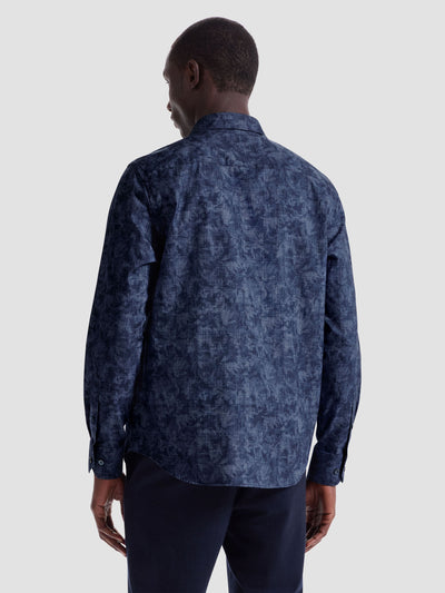 A man is shown from the back against a plain light background wearing the Bugatchi Axel Woven Sport Shirt HS3050L40S, a long-sleeve patterned cotton shirt by Bugatchi, paired with dark pants.