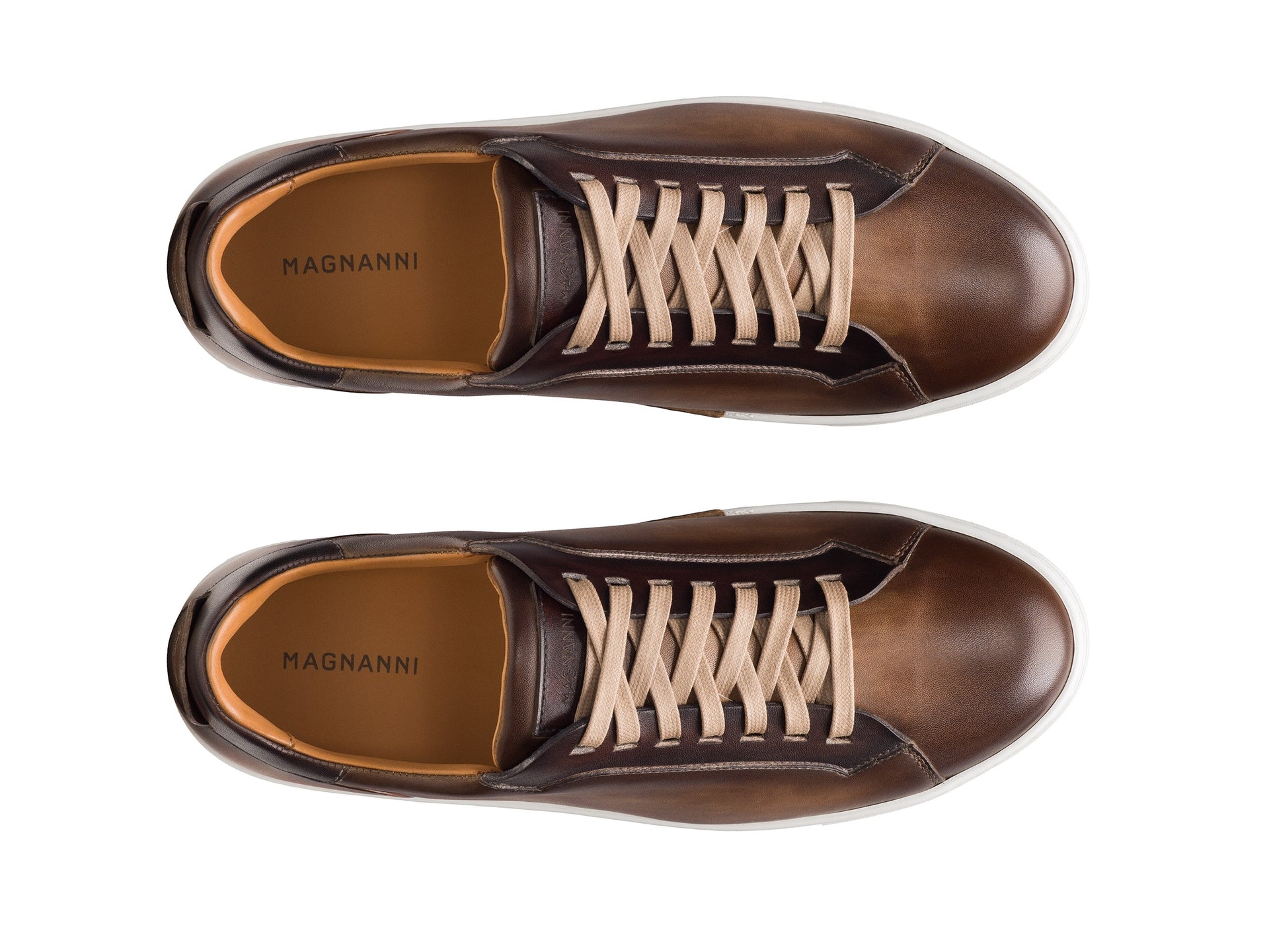 A pair of Magnanni Amadeo brown leather sneakers with beige laces and a leather toe, seen from above on a white background.