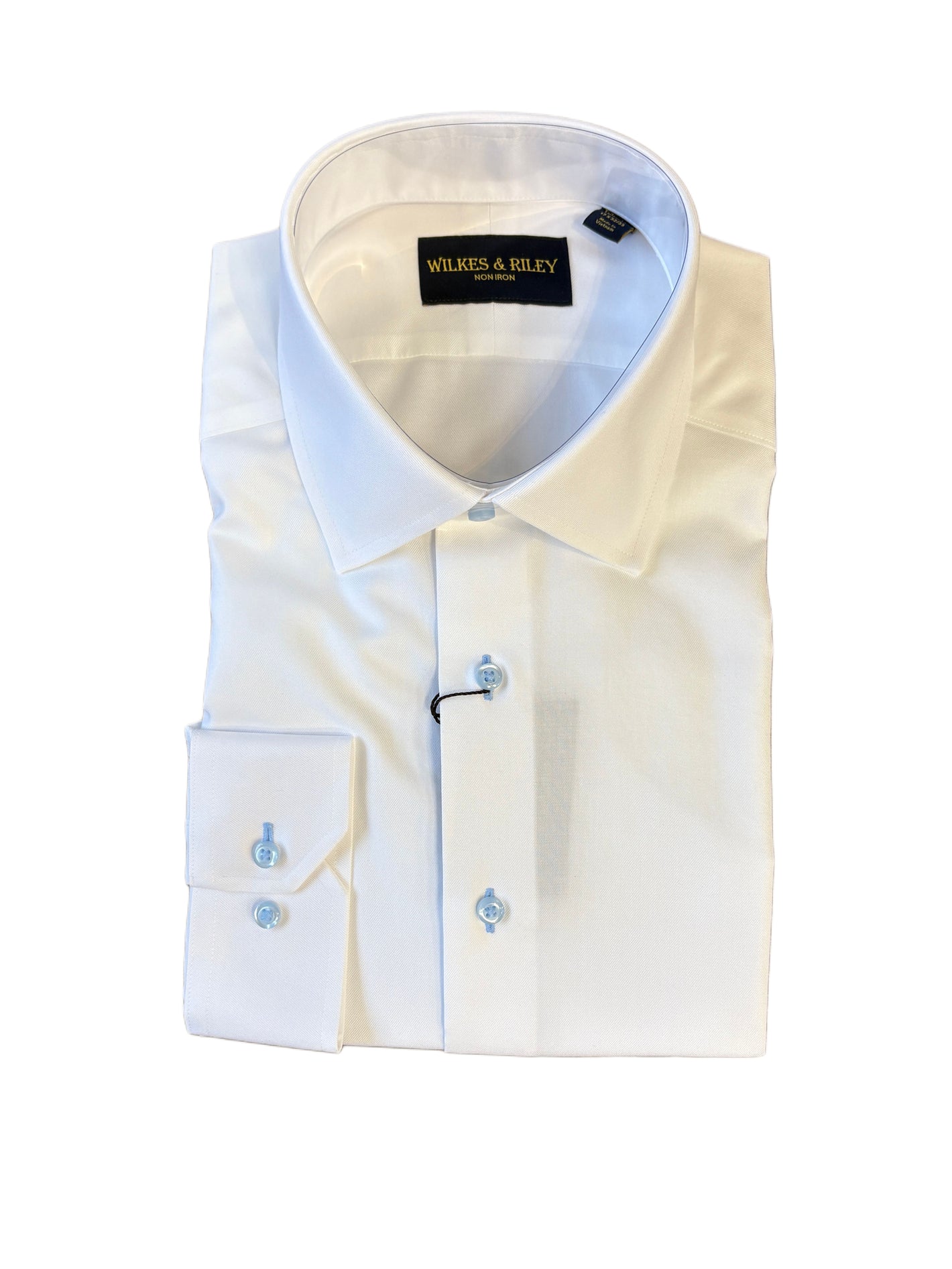 A folded Wilkes & Riley White/Sky Spread Collar B1715 dress shirt, featuring long sleeves, a white fabric with light blue buttons, and the Wilkes & Riley label, displayed on a white background.