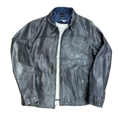 The Missani Vintage Leather Jacket 392794 is a timeless black leather jacket with a collar, zip closure, two side pockets, and a stylish patterned blue lining partially visible when displayed flat.