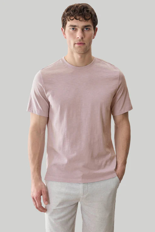 A man wearing a light pink Robert Barakett Georgia Crew 23336 Pima cotton tee and light gray pants stands against a plain gray background.