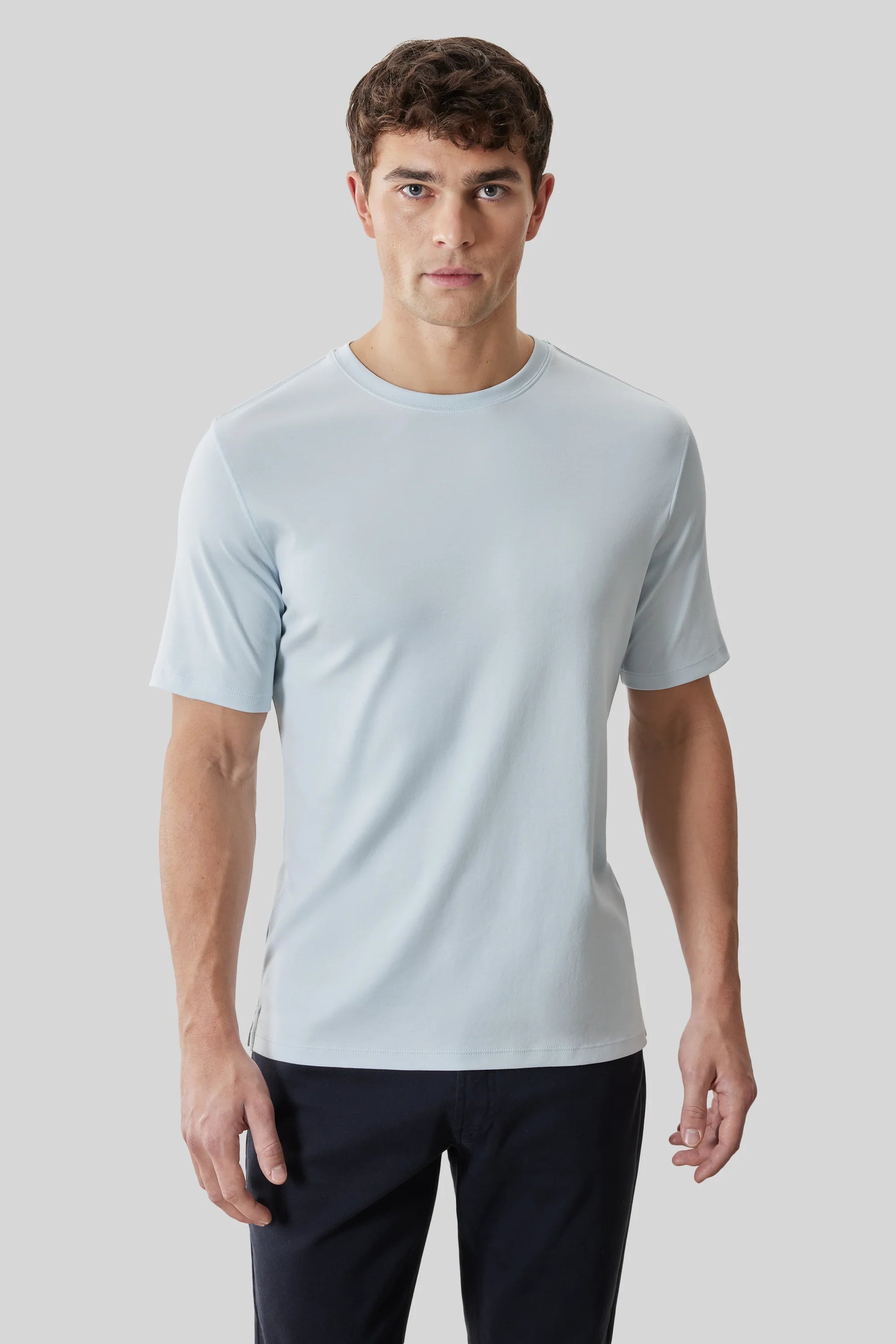 A man wearing the Robert Barakett Tee Shirt Georgia Crew 23336 in light blue and black pants stands against a plain light gray background.