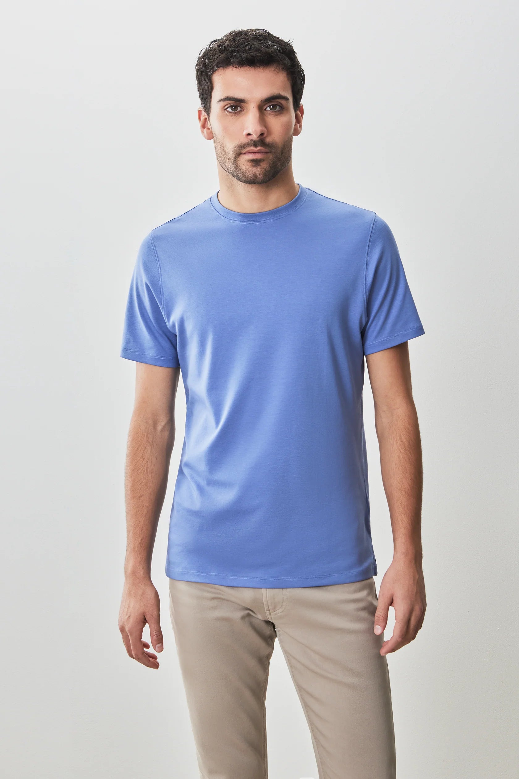 A man stands against a plain light background, wearing the Robert Barakett Georgia Crew 23336 Pima cotton tee in light blue and beige pants, looking directly at the camera.