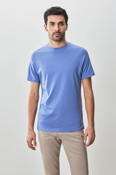 A man stands against a plain light background, wearing the Robert Barakett Georgia Crew 23336 Pima cotton tee in light blue and beige pants, looking directly at the camera.