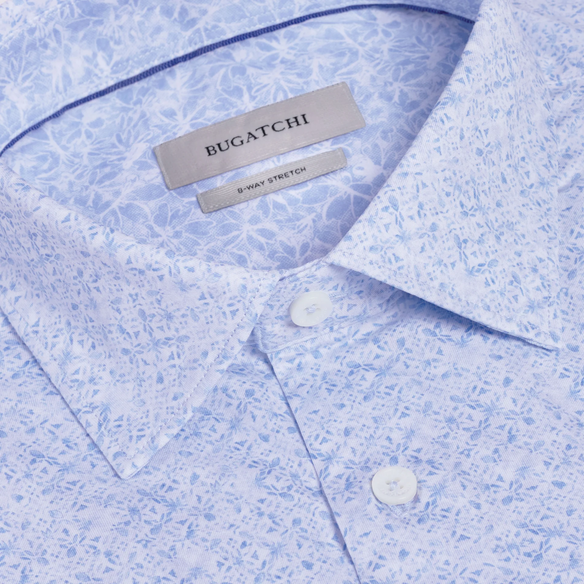 Close-up of the Bugatchi OP Jimmy OoohCotton® Floral Shirt JF9635K61, featuring a light blue floral pattern, spread collar, white buttons, visible brand label, and 8-way stretch tag in this innovative performance fabric.