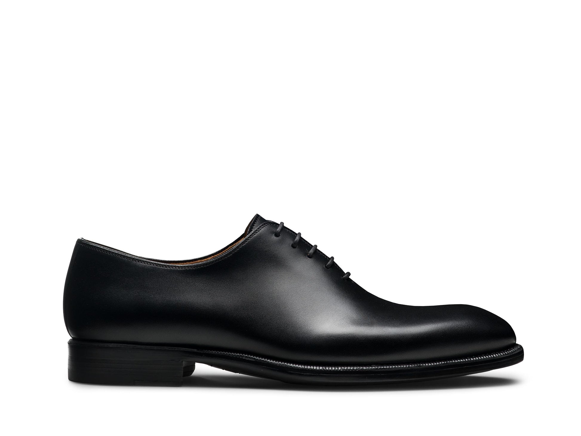 The Magnanni Hawkins Wholecut Oxford Dress Shoe by Magnanni, crafted from black calfskin leather with closed lacing, is shown from the side against a white background.