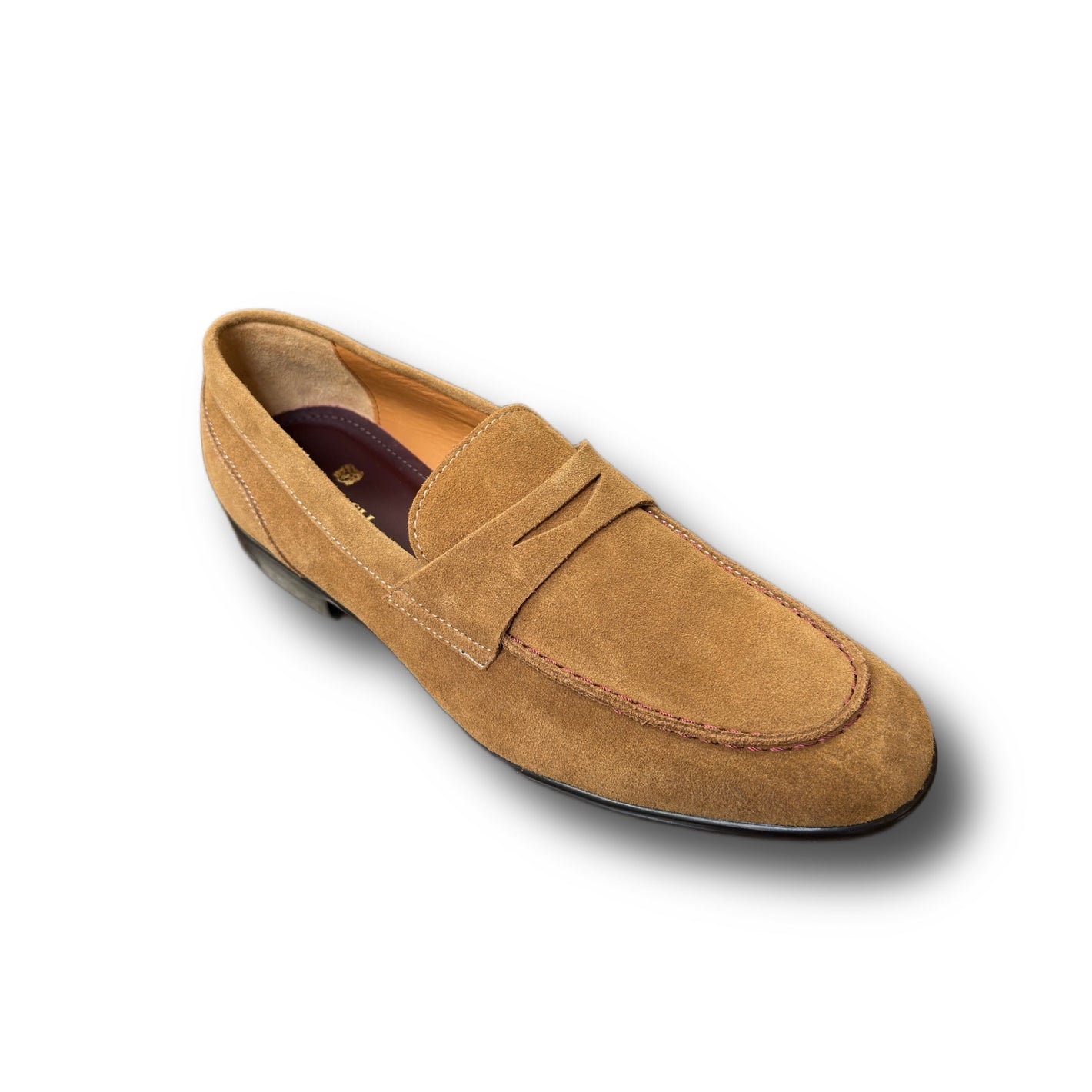 The Bruno Magli Silas Loafer is a tan Italian suede penny loafer with a penny strap, visible stitching, and a low black heel, shown on a white background.