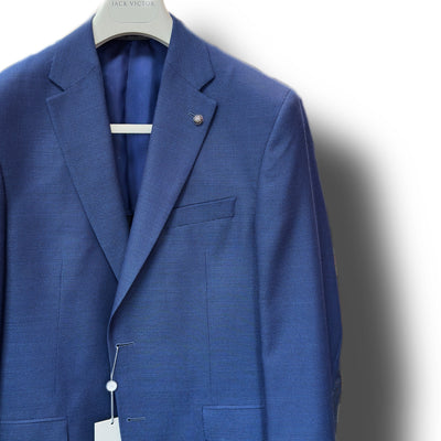 The Jack Victor Sport Coat Blue 161150, featuring a tailored fit and crafted from 100% wool, is displayed on a hanger against a white background with tags attached to the buttonhole and collar label.