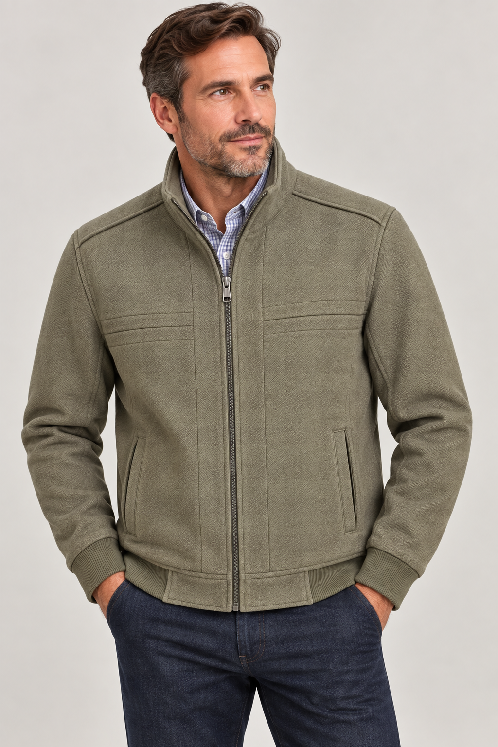 A man wearing the Enzo Oliver Seam Detailed Jacket in olive green over a wrinkle-resistant OoohCotton shirt, paired with dark jeans, stands against a plain light background.