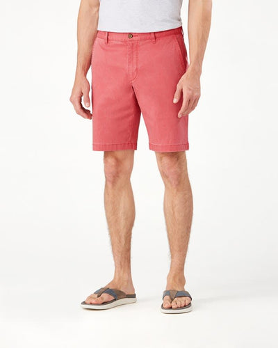 A person wearing a gray t-shirt, gray sandals, and Tommy Bahama Boracay Shorts Big & Tall in salmon pink stands against a white background.