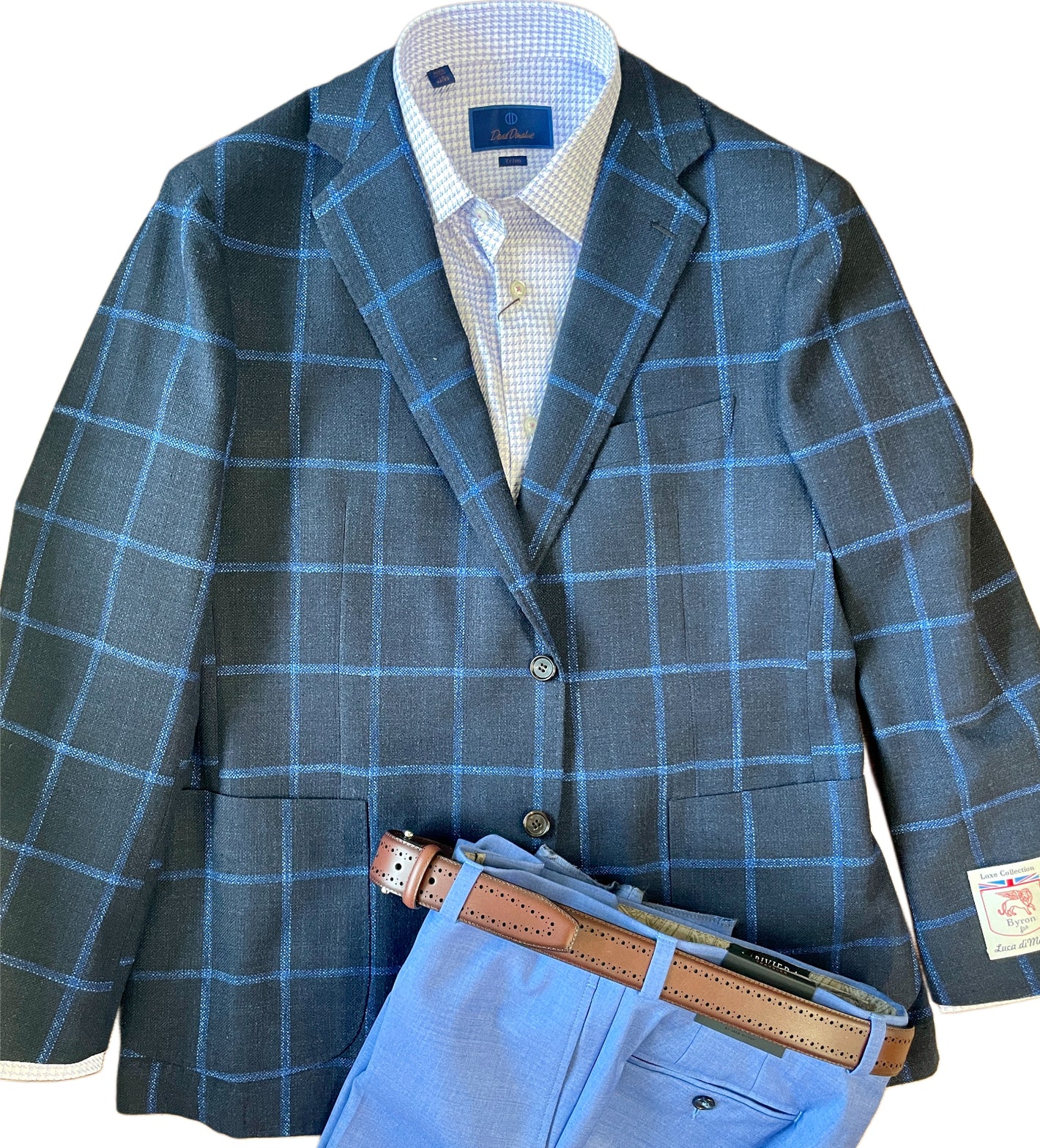 The Byron Luca Sport Coat Windowpane 9575 by Byron offers a modern fit with a blue windowpane plaid, styled over a light blue checkered shirt, complemented by light blue trousers and a brown leather belt.