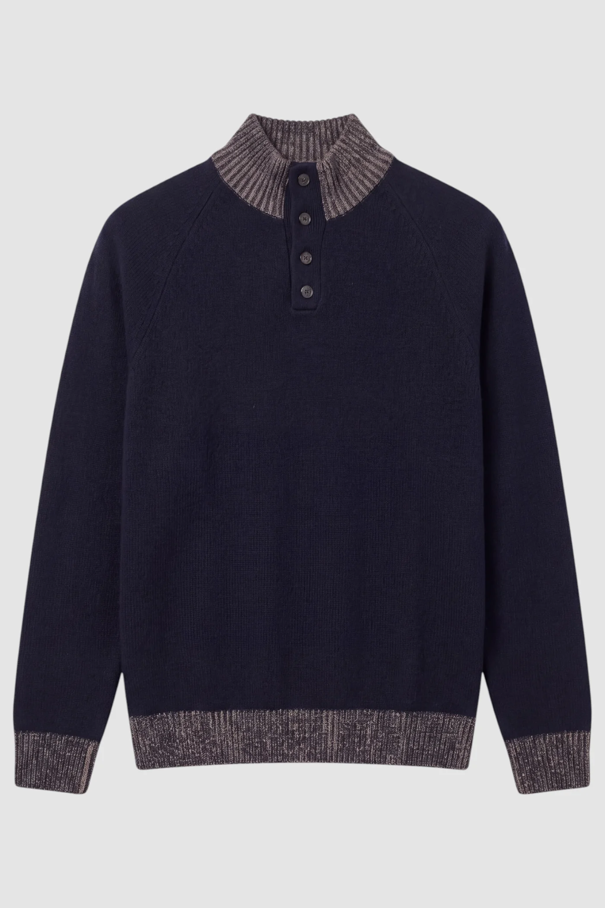 The Garnet Tate Contrast-Trim Mock Neck Sweater 2622022 by Garnet is a navy blue men’s wool-blend sweater featuring a high ribbed collar with four front buttons, and contrasting gray ribbed cuffs, collar, and hem. Laid flat on a plain background, this refined knit showcases its contrast-trim mock neck design for an effortlessly polished look.