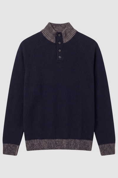 The Garnet Tate Contrast-Trim Mock Neck Sweater 2622022 by Garnet is a navy blue men’s wool-blend sweater featuring a high ribbed collar with four front buttons, and contrasting gray ribbed cuffs, collar, and hem. Laid flat on a plain background, this refined knit showcases its contrast-trim mock neck design for an effortlessly polished look.