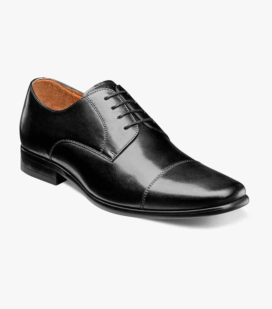 The Florsheim Postino Plain Ox Black Smooth, a sleek leather oxford dress shoe with laces, offers all-day comfort and is shown on a plain white background.