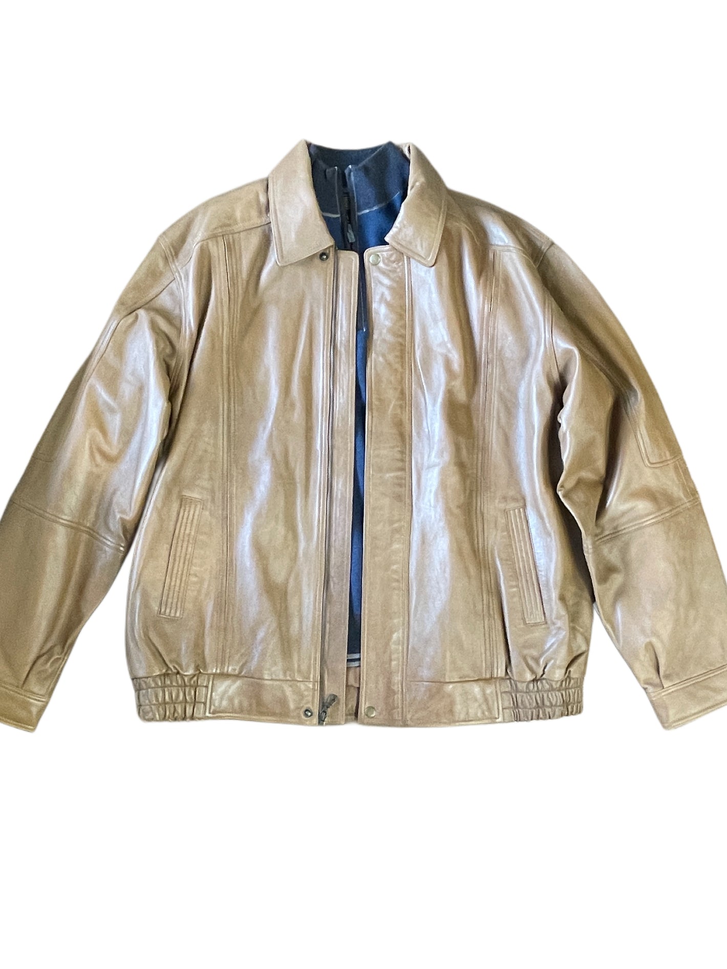 The Scully Lambskin Leather Jacket 978 by Scully features tan lambskin, a collar, front zipper, side pockets, and an elasticized hem—a stylish men's outerwear piece shown on a white background.