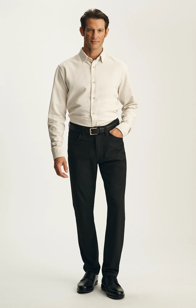A man stands against a plain background wearing the 34 Heritage Courage Supreme Plaid pants by 34 Heritage, his hands relaxed at his sides.