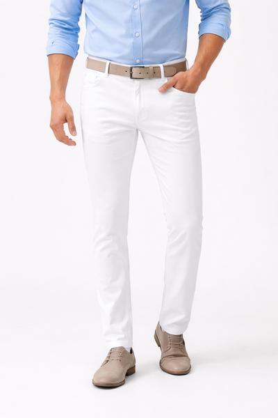 Man wearing Alberto Pipe 1582 Color Denim Big & Tall pants by Alberto, styled business-casual with a light blue button-up shirt, beige belt, and beige dress shoes, posing against a plain background with one hand in his pocket.
