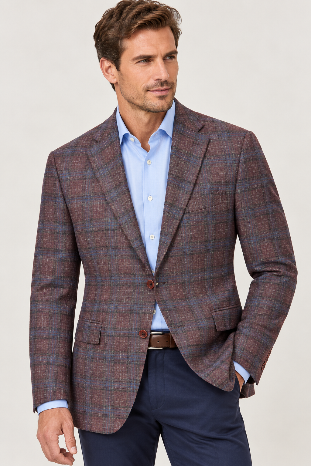 A man wearing a Hart Schaffner Marx New York Burgundy Plaid Sport Coat 35H0128 over a light blue button-down shirt and dark trousers.