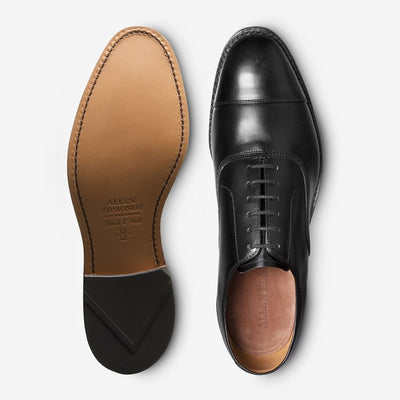 The Allen Edmonds Park Avenue is a pair of black leather Oxford dress shoes, shown from the top and sole, crafted from premium European calfskin with Goodyear welt construction and a stitched leather outsole.