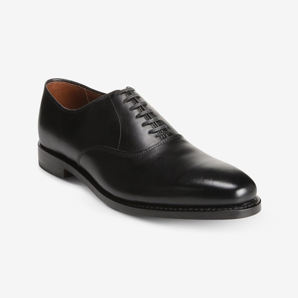 The Allen Edmonds Carlyle by Allen Edmonds is a black oxford dress shoe with closed lacing, a low heel, and plain toe, crafted from handcrafted leather and shown against a white background.