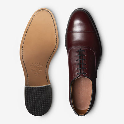 Two views of the Allen Edmonds Park Avenue men's oxford in dark brown European calfskin: one shows the leather sole, while the other highlights its cap toe and closed lacing from above.