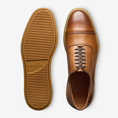 A pair of Allen Edmonds Park Avenue Oxford Dress Sneakers, shown from top and bottom, feature premium leather with laces and rubber soles; "Allen Edmonds" is stamped on the sole.