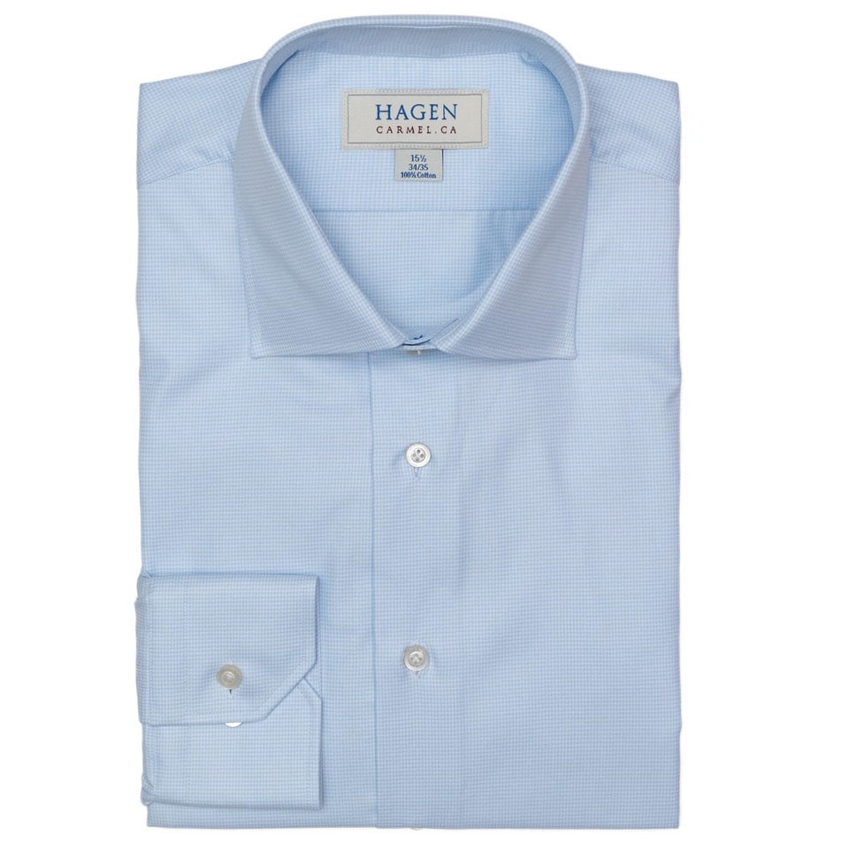 A neatly folded Hagen Houndstooth Dress Shirt (MB8852450) in light blue premium cotton, with the Hagen brand label visible inside the collar.