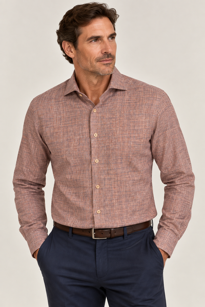 A man wears the Elite Serica Elite Textured Print Sport Shirt EX2674150—a long-sleeve, button-up brown sport shirt—tucked into navy pants with a brown belt. He stands with his hands in his pockets, looking to the side against a plain background.