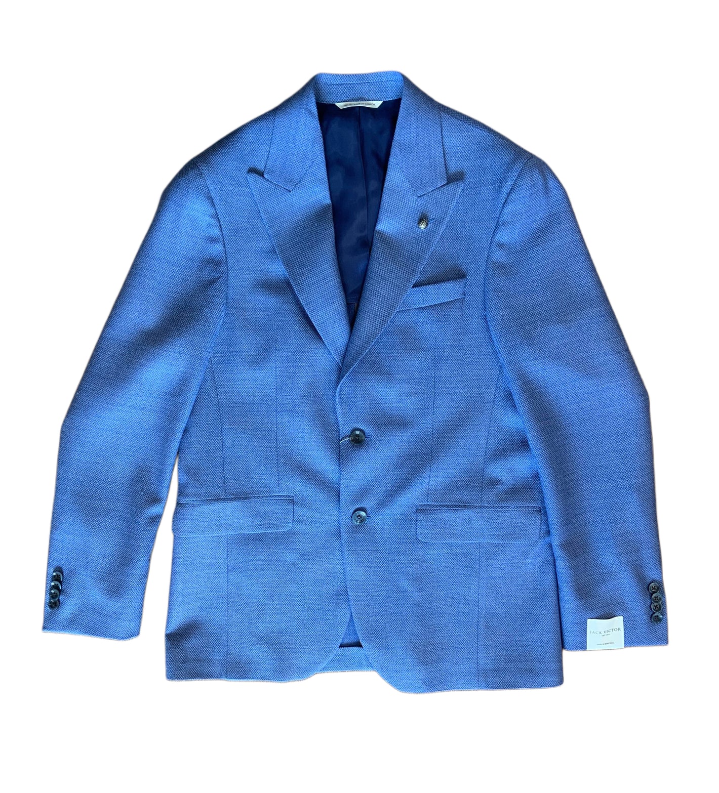 The Jack Victor Sport Coat Marcus 1251109 is a single-breasted blue blazer with notch lapels, three front buttons, flap pockets, and a visible white label on the left sleeve.