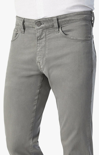 A person wears 34 Heritage Pewter Twill light gray slim-fit jeans made from stretchy twill and a white textured shirt, shown waist to mid-thigh against a plain background.