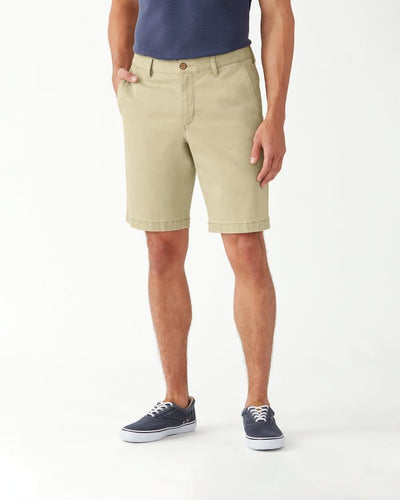 A person wearing Tommy Bahama Boracay Shorts Big & Tall, a navy shirt, and navy sneakers stands with hands in pockets against a plain white background.