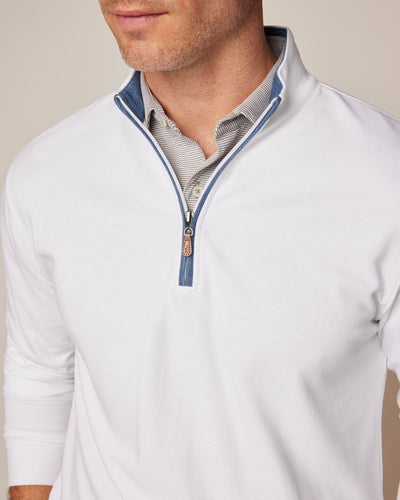 A man wears the Johnnie-O Sweater SULLY 1/4 Zip, a white cotton-blend pullover, over a collared striped shirt. The quarter-zip is partially open to show the blue inner collar detail.