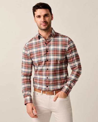 A man stands against a plain light background wearing the Johnnie-O Knick Flannel Plaid Shirt Big & Tall in red, blue, and white plaid by Johnnie-O, paired with beige pants and a brown belt.