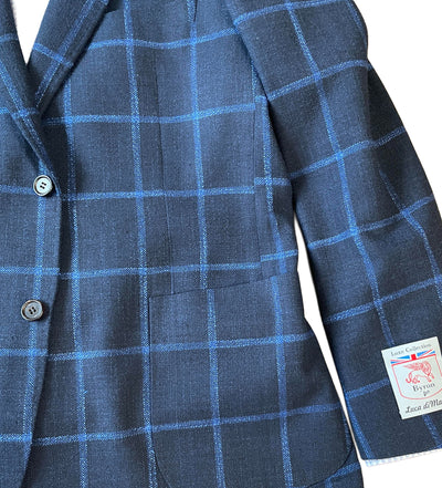 The Byron Luca Sport Coat Windowpane 9575 is a modern fit navy sport coat with a light blue windowpane pattern, two buttons, and a visible Byron brand label on the sleeve.