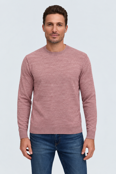 A man wears a dusty rose Raffi Merino Classic Crew Neck Sweater - The Alfie - HWC19392 and blue jeans, showcasing fine Italian yarn craftsmanship.