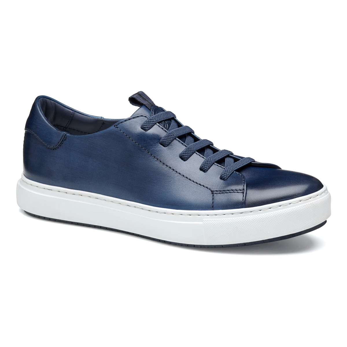 The Johnston & Murphy Anson sneaker by Johnston Murphy features navy blue full grain leather, matching laces, and a thick white rubber sole with a cushioned EVA outsole, shown against a white background.