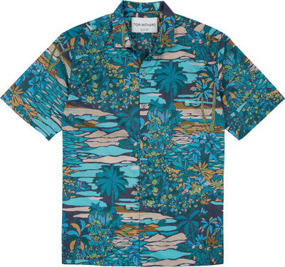 The Tori Richard Printed Cotton Opalescent Shirt 1956M0330 is a short-sleeved button-up featuring a blue, green, and brown tropical landscape print with palm trees and foliage.