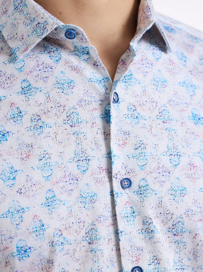 Close-up of a person wearing the Robert Graham Greatorex Woven Shirt Big & Tall by Robert Graham, a light-colored short sleeve shirt with an allover blue and purple abstract print, blue buttons, and tailored edges.