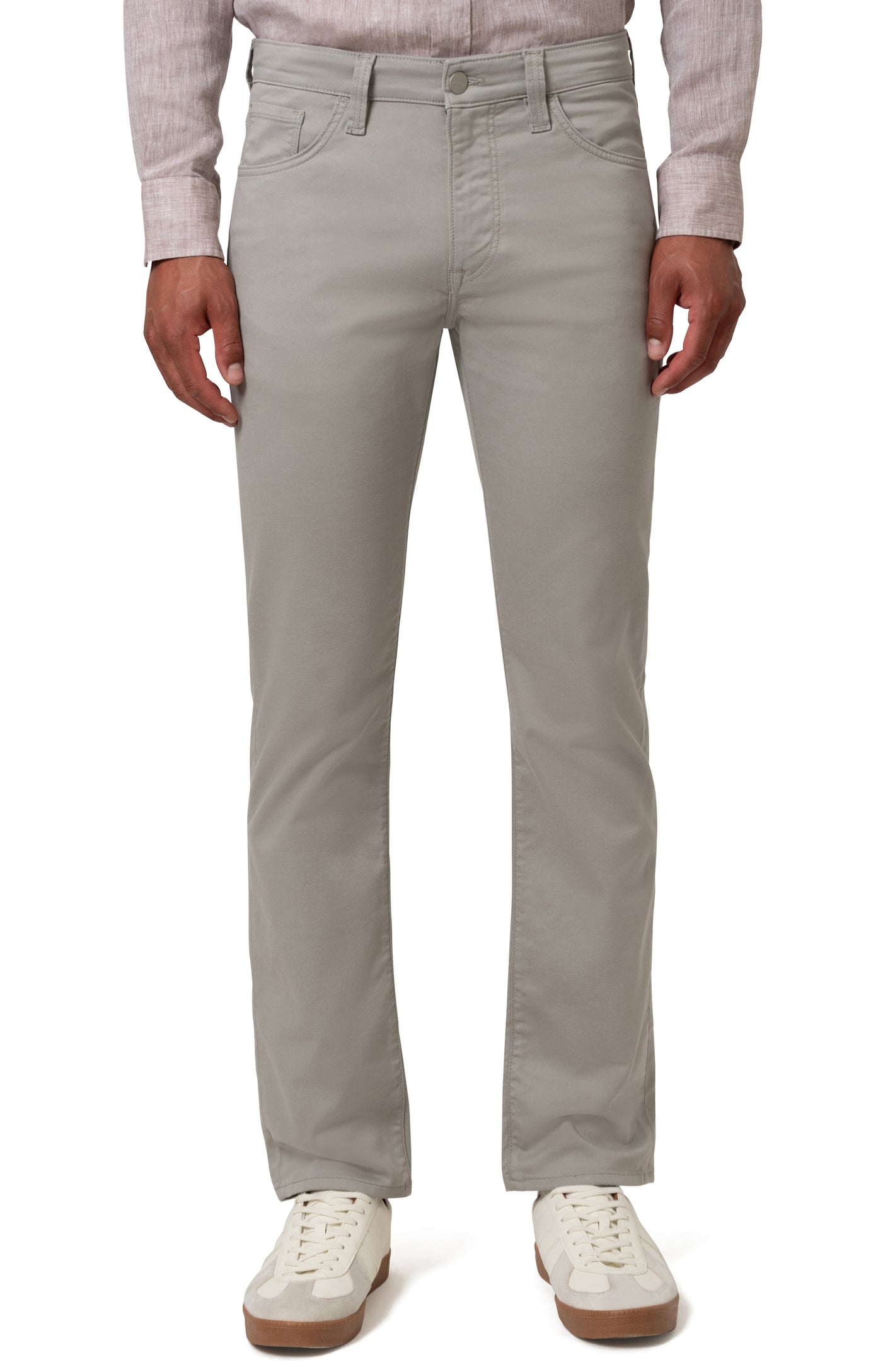 A person models 34 Heritage Charisma Coolmax Big & Tall Jeans by 34 Heritage—light gray, sweat-wicking denim—paired with a light shirt and white sneakers against a white background.