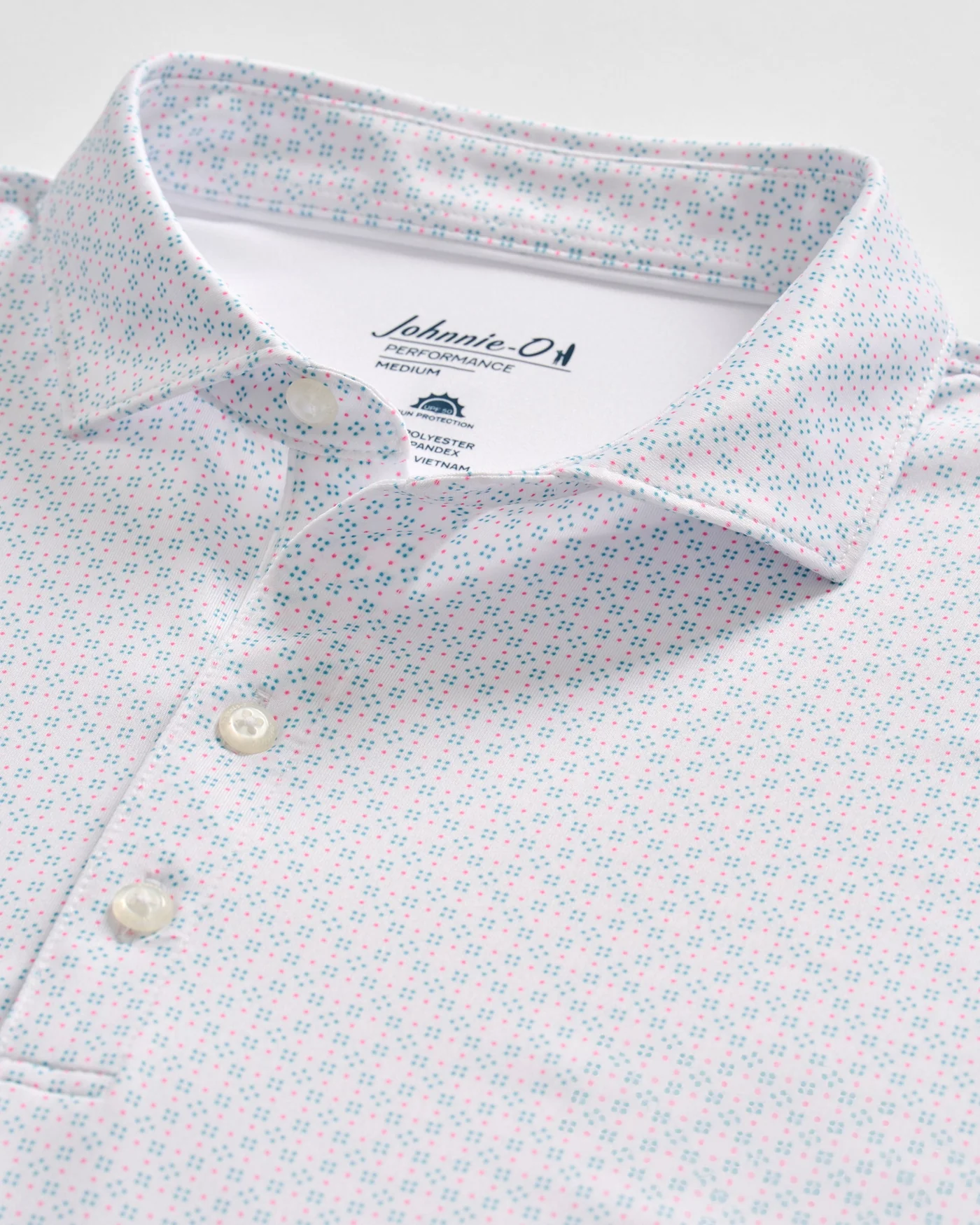The Johnnie-O Torres Performance Big & Tall Polo is a light-colored casual shirt with a subtle blue and red geometric pattern, white buttons, and visible Johnnie-O branding on the inner collar.