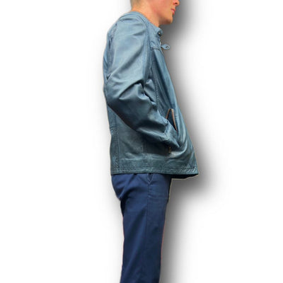A person in a blue Missani Leather Jacket 392834 by Missani and blue pants stands in profile against a white background.