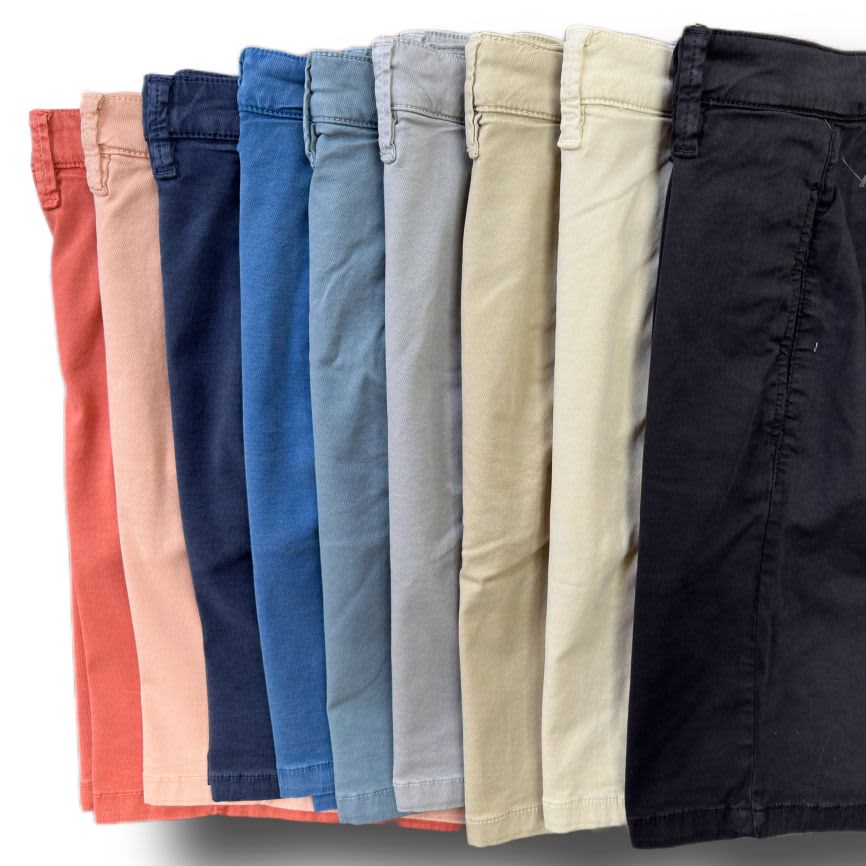 Nine pairs of 34 Heritage Nevada Soft Touch Shorts by 34 Heritage, in slim fit and assorted colors like coral, blue, beige, and black, are arranged side by side in a row.